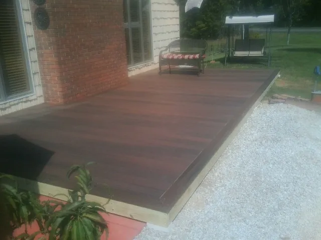 Freshly stained wood deck built against a brick home in Stanton